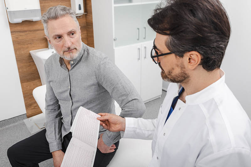 Doctor talking to an older man in a doctor's office
