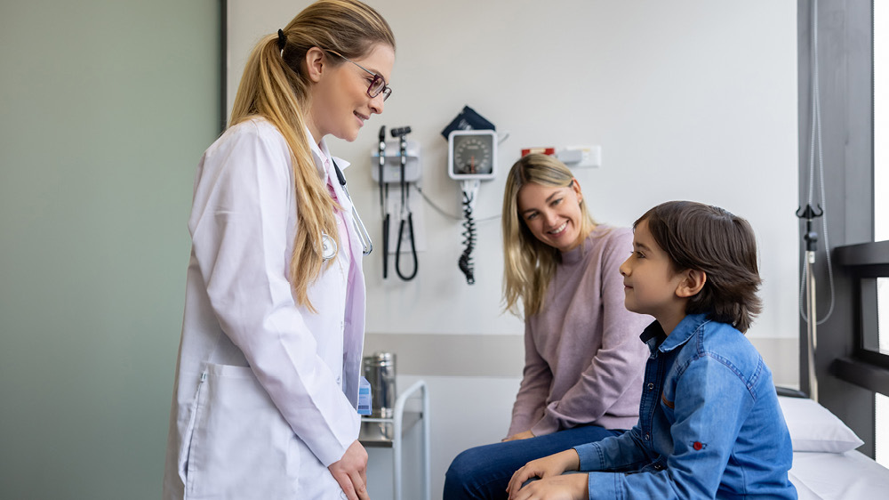 young boy with mom being seen by female doctor