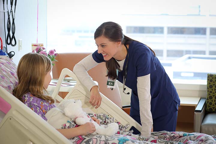 Nurse talking to a child in a hospital bed